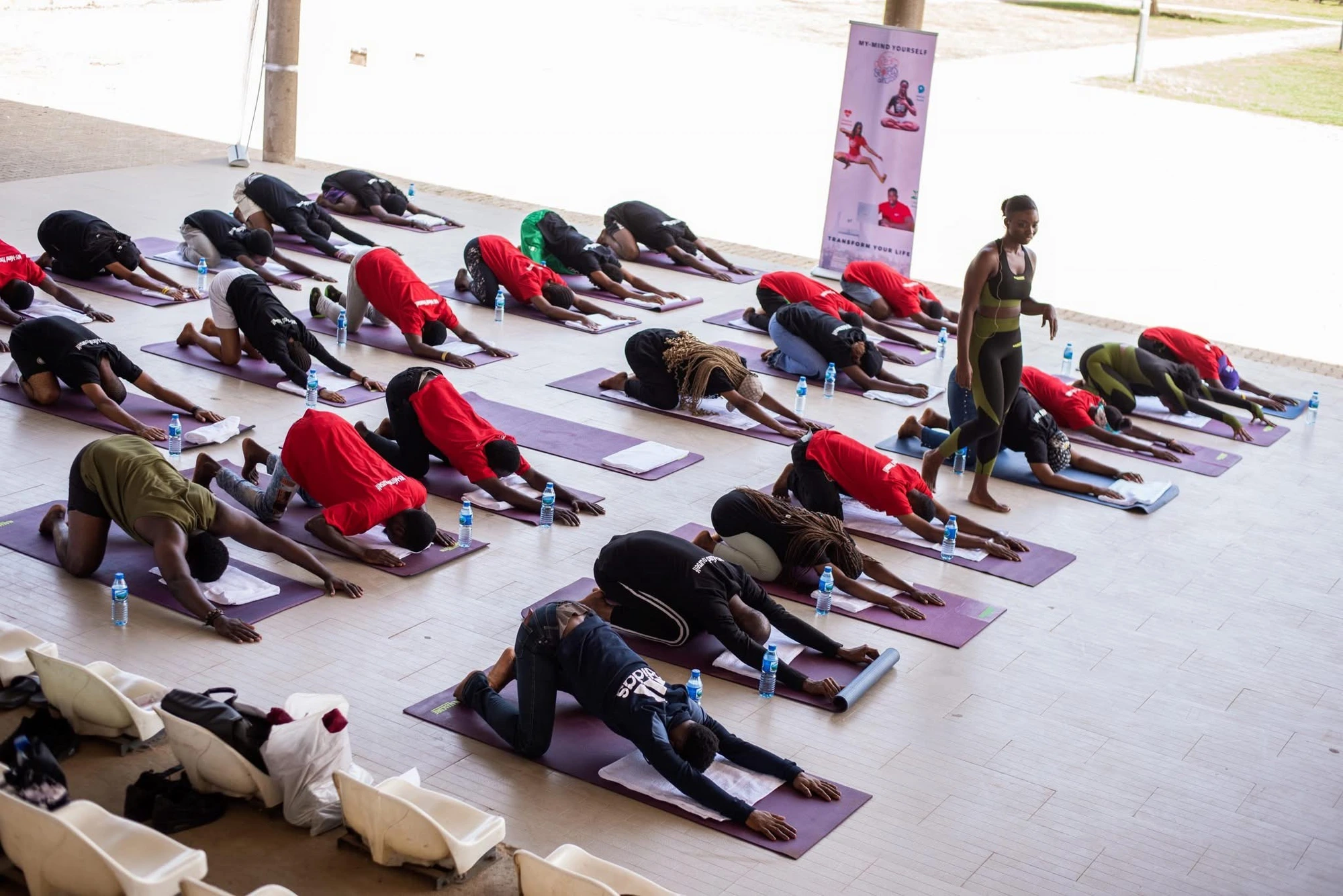 A Dream Sports Africa coach guiding a large group through a yoga session