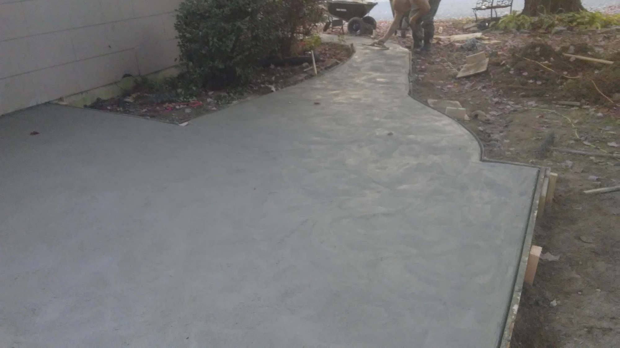 Finished curved concrete walkway alongside home