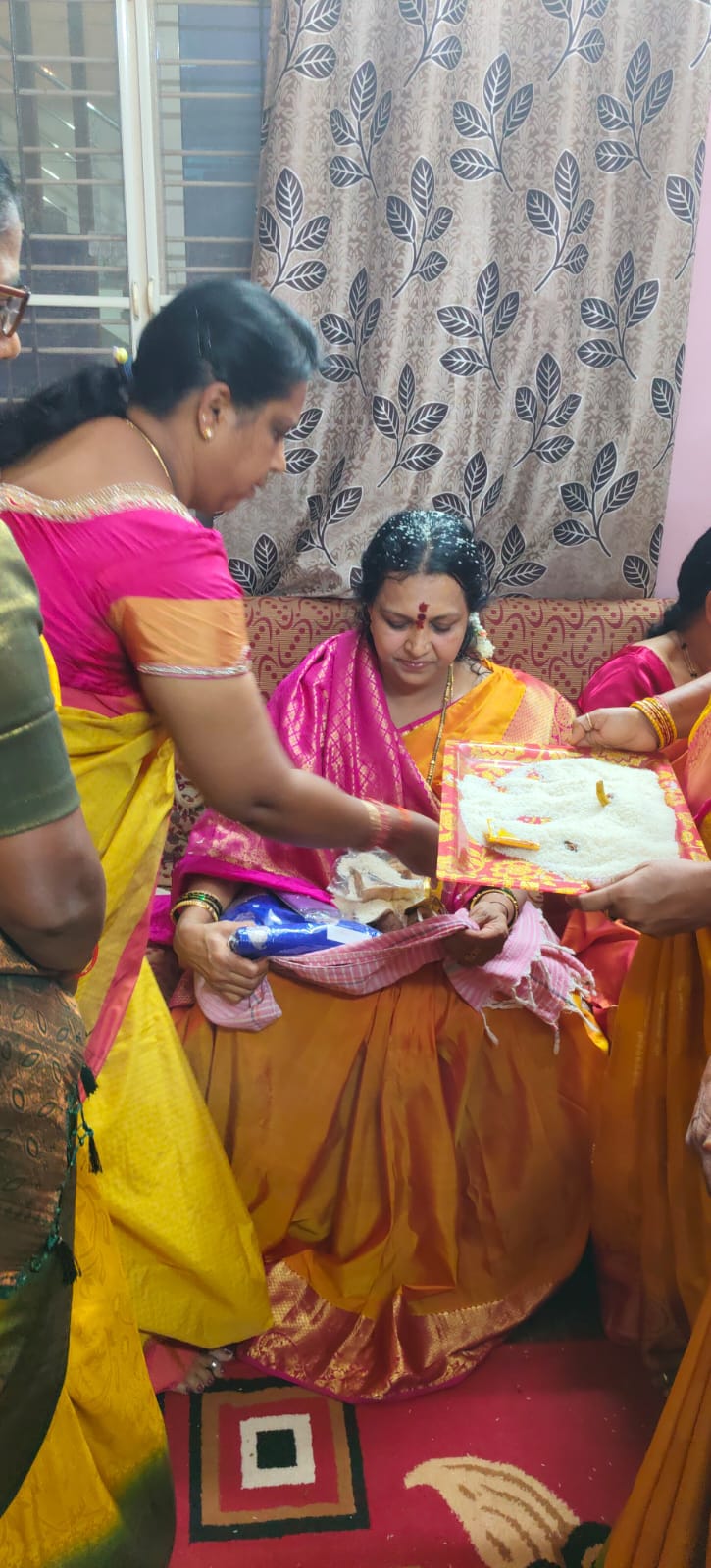 A group gathered for a home parayana with the parayana booklets