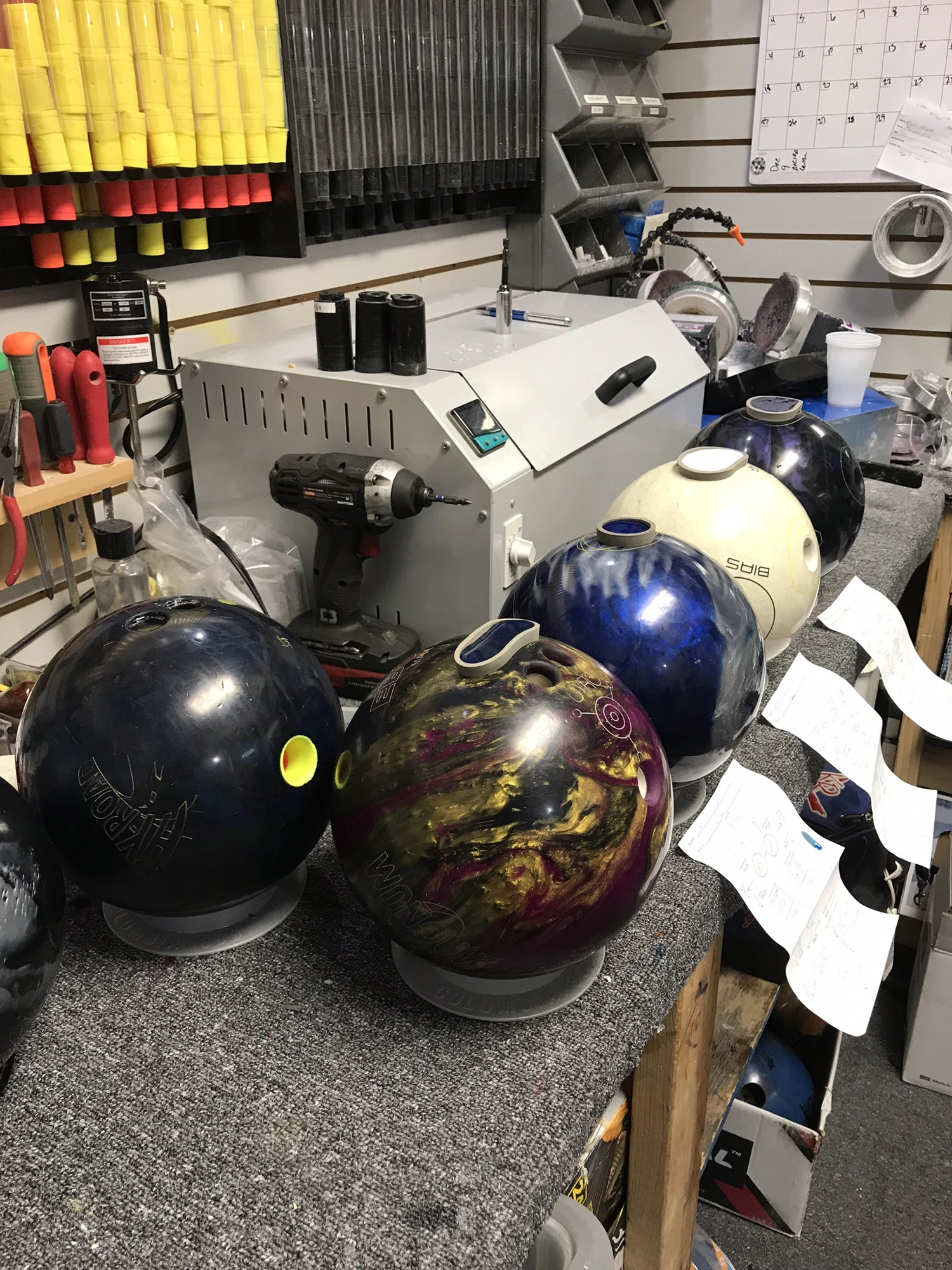 Workbench in the pro-shop with customer balls lined up next to the ball heater