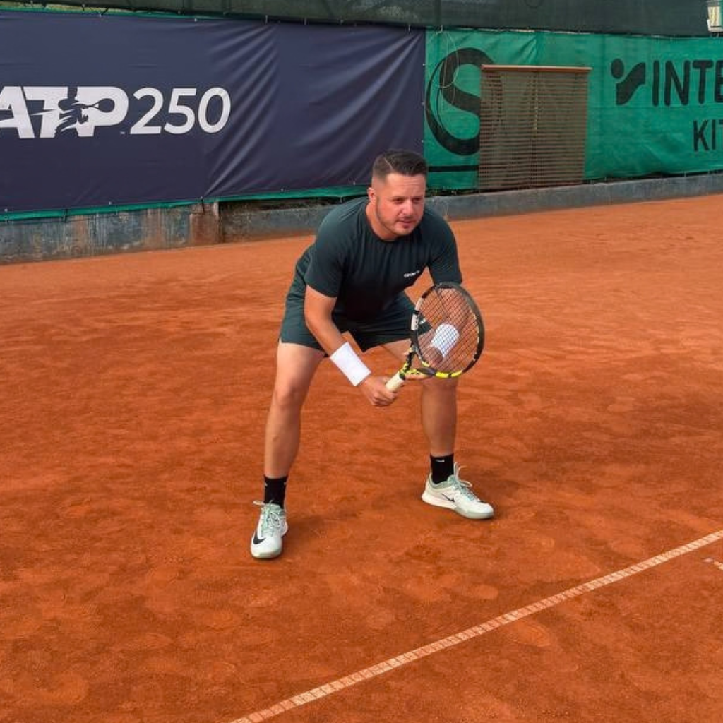 Daniel, Gründer von MatchGrit, in Return-Position auf dem Sandplatz
